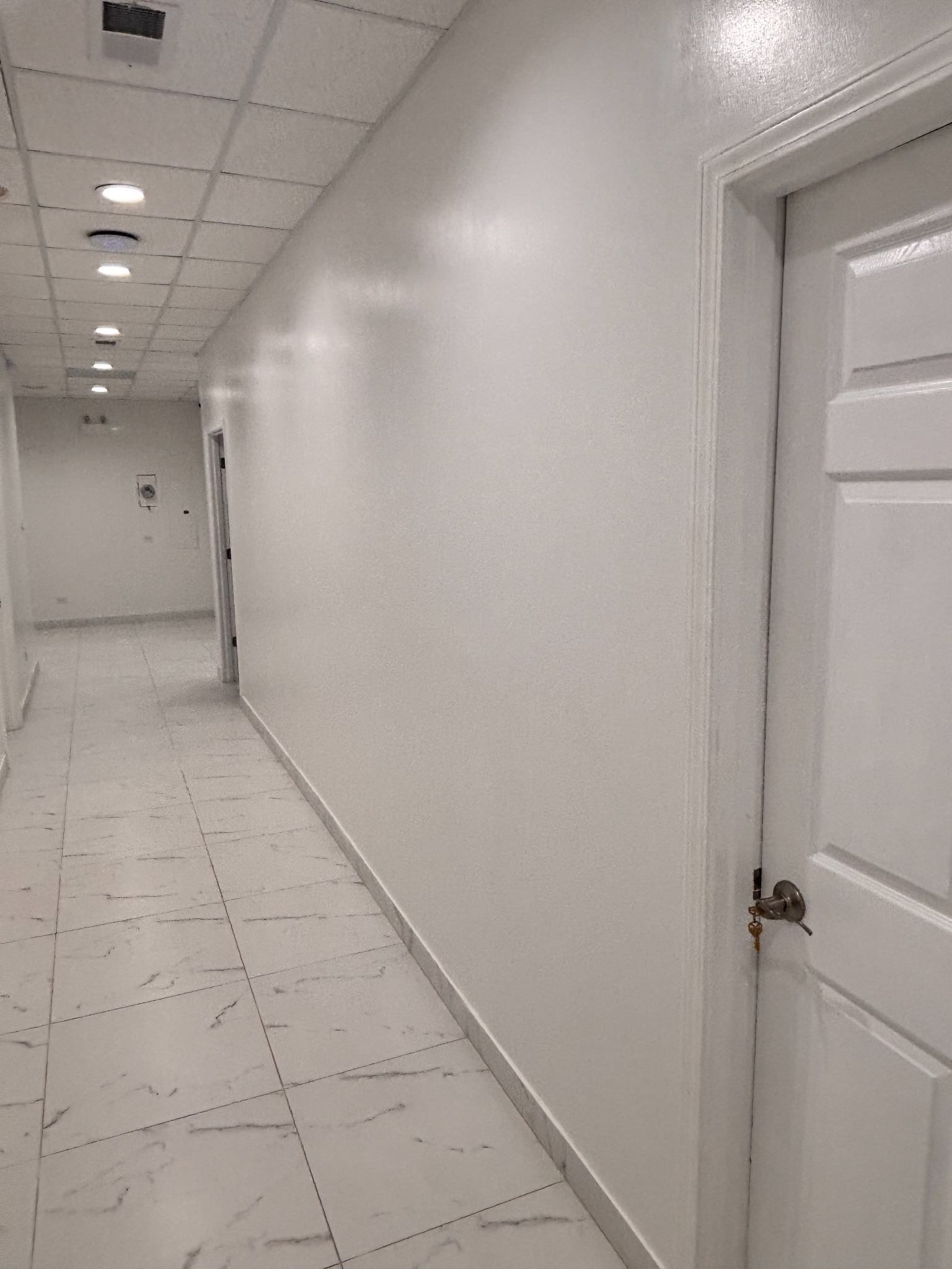 Right hallway leading to Bonita Salon suites before built-in storage, gold wall detailing, and an end mirror