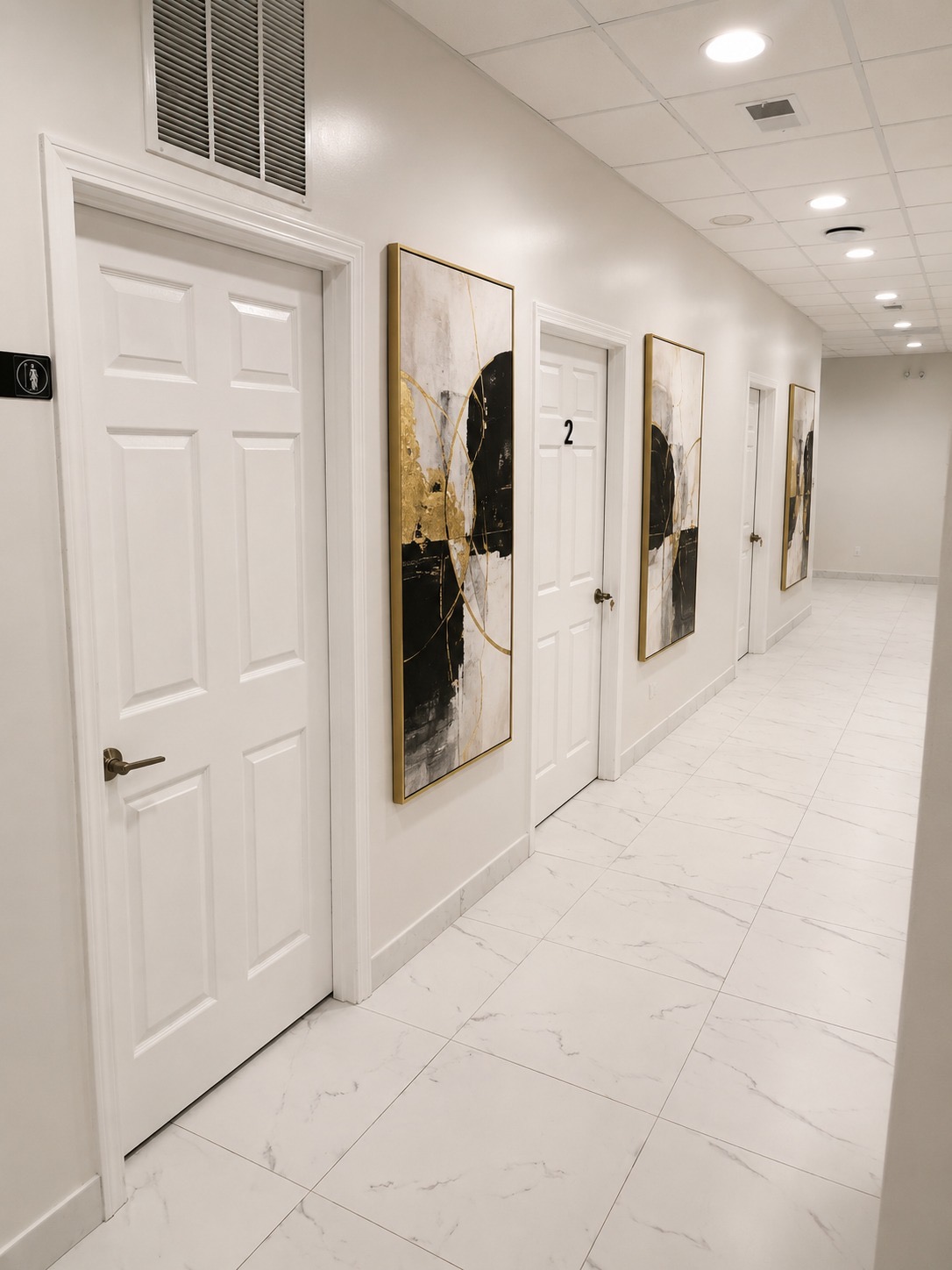 Left hallway leading to Bonita Salon suites after adding coordinated black, ivory, and gold abstract artwork