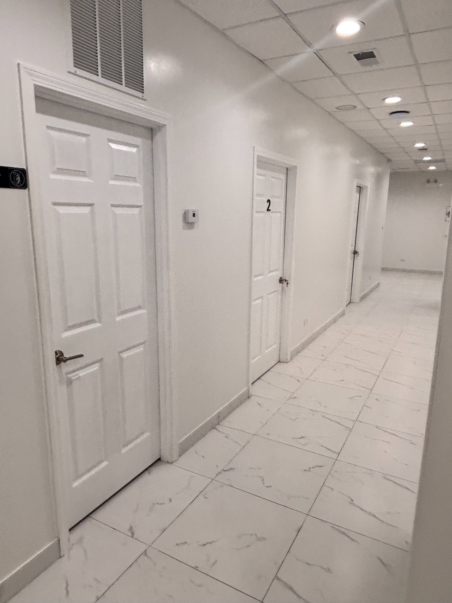 Left hallway leading to Bonita Salon suites before coordinated artwork was installed between the suite doors